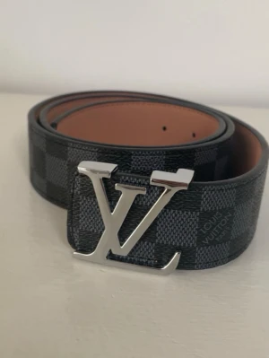 Lv bälte (helt nytt) - Säljer detta sprillans nya LV bältet i svart samt rutig färg med ett silvrigt spänne. Bältet är helt nytt aldrig ens testad! Kontakta mig via funderingar.