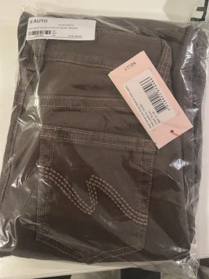 Bruna bootcut jeans från Nelly - Säljer ett par bruna low waist bootcut jeans från Nelly, jättefina byxor men beställde i fel storlek. Storleken är 38, M, 10. Helt nyskick och kommer i påsen som jag fick de i!