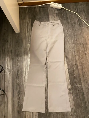 Grå kostymbyxor från BikBok - Snygga ljus grå kostymbyxor från BikBok i rak modell med vida ben, absolut mina favoriter men sitter för thight. 