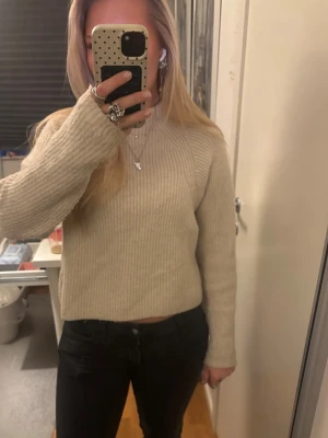 Ljusbeige ribbad stickad tröja - Mysig ljusbeige stickad tröja med ribbad struktur och en hög krage/turtle neck. Tröjan är ifrån kappahl och är i storlek xs!