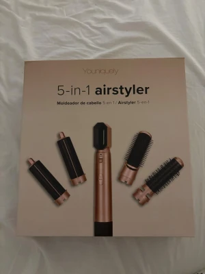 Youniquely 5-i-1 airstyler - Multifunktionell 5-i-1 airstyler från Youniquely i svart och guld. Inkluderar flera utbytbara borsthuvuden och locktillbehör för styling av hår. Perfekt för att skapa olika frisyrer med ett enda verktyg. Elektrisk med sladd och ergonomisk design. Har testat ett stycke för att se att allt funkade men kommer ej till användning