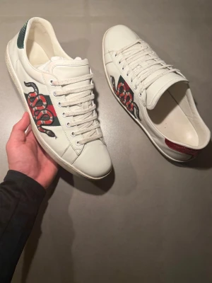 Gucci vita sneakers med orm - ‼️VI TAR INGA BYTEN‼️ Gucci ”Ace” Sneakers | Skick: 8,5/10 | Storlek UK 10,5 motsvarar 45-46  | Tillkommer box & kort vid köp! | Frakt sker inom 24 timmar efter köp 📦💨 | Hör av dig vid minsta fråga eller fundering 💭