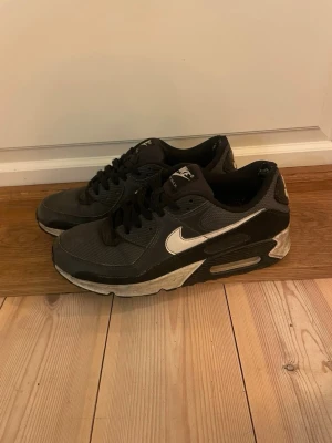 Nike Air Max 90 - Nike Air Max 90 | Svart/Vit/Grå | EU 43   Skicket är helt okej, slitna hälar inuti (känns inte alls när de är på) och ena hälen är rätt sliten på utsidan, vilket man knappt tänker på. Annars är de fina efter en snabb tvättning. 🙌