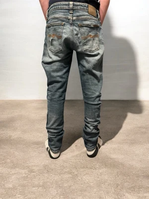 Nudie Jeans - Säljer ett par Nudie jeans med slitningar. Jeansen är i mycket bra skick förutom en liten fläck som inte syns när man har på sig dem. Slitningarna är originellt från fabriken vilket är väldigt eftertraktat och populärt. Nypris ca 1000kr, säljs för 249kr. 