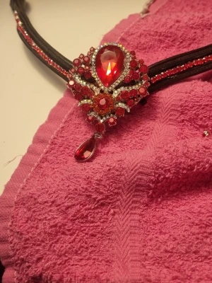 pannband med röda stenar - Ett snyggt pannband med svarta band och en stor, droppformad röd sten 