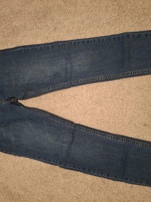 DSQUARED2 jeans - Säljer ett par blå jeans med smal passform och klassisk tvätt. Jeansen har fem fickor och raka ben. Perfekta till en avslappnad stil och passar till det mesta. Materialet är troligtvis bomullsdenim.