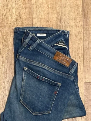 Replay blå jeans slim fit (Katewin) 31/32 - Snygga blå jeans från Replay med klassisk femficksdesign och läderpatch bak i midjan. Jeansen har en slim passform och är tillverkade i mjukt denimtyg som ger en bekväm känsla. Perfekta för dig som gillar en stilren och modern look. Storlek 31/32. Snabb leverans! 
