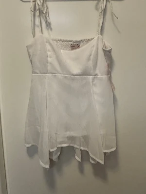 Vit top Nelly  - Super SNYGG vit top från Nelly som är helt oanvänd med prislappen kvar. Är i str S