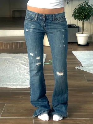 Abercrombie & fitch Lågmidjade jeans  - Ett par jeans från Abercrombie & fitch i storlek ”0” vilket motsvarar en vanlig XXS/XS. Rakt över midjemått: ca 35cm. Innebenslängd: ca 82cm. Jag är 165cm på bild. Jag fraktar inom 24h, frakt med PostNord prioriteras. Se liknande plagg i min profil!