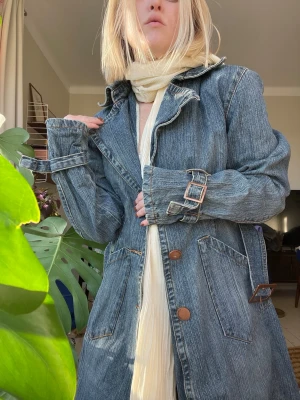 Kappa i denim  - 💙 denimkappa som påminner om en klassisk trenchcoat. Kappan har blå tvätt med snygga skiftningar som ger den en autentisk vintage-känsla. Storlek uppskattas till S/M. ✨Se även mina andra annonser, 3 för 2 på allt! ✨