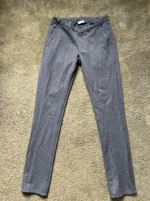 Grå chinos - Grunt - Snygga grå chinos med smal passform och klassisk design. Byxorna är från Grunt. Ny pris 600kr , mitt pris 250kr. Storlek: 27 , passar 174+