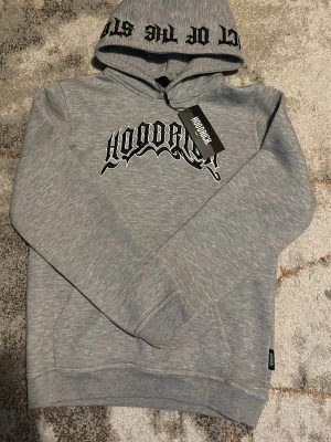 Grå hoodie från Hoodrich med tryck - Snygg grå hoodie från Hoodrich med svart och vitt tryck på bröstet och text på huvan. Oanvänd 