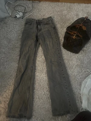 Grå jeans från Gina Tricot, perfect jeans, stl 34 - Säljer ett par grå jeans från Gina Tricot i rak/bootcut modell. Klassisk femficksdesign, normal passform och Jeansen har en snygg tvättad look och är tillverkade i slitstarkt denimtyg. Perfekta till sneakers eller boots. De är högre i midjan.