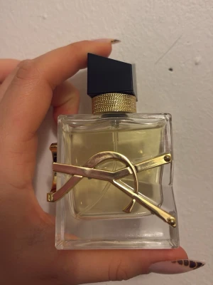 Trendig parfym med lyxig design - En ikonisk parfym från Yves Saint Laurent med elegant och modern flaska, dekorerad med guldiga detaljer. Perfekt för dig som vill sticka ut och addera en exklusiv touch till din stil.