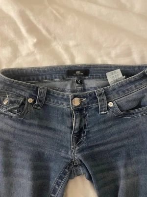 True Religion Joey Low Rise Flare Jeans - Säljer ett par blå True Religion Joey jeans med låg midja och som är flare .