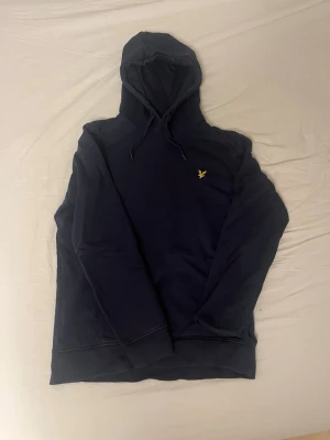 Lyle & Scott hoodie S - En blå Lyle & Scott hoodie i nyskick. Det står att den är storlek M men den är liten i storleken närmare S. Perfekt för kalla dagar i bland annat skolan