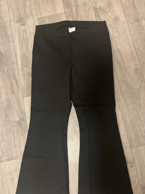 Svarta bootcut byxor Gina Tricot XL - Säljer ett par svarta bootcut byxor från Gina Tricot, basically basics-kollektionen. Byxorna är tillverkade i ett stretchigt material som sitter snyggt. Perfekta till en enkel topp eller hoodie.