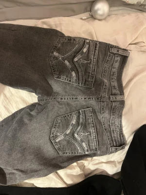 Grå jeans från Gina Tricot, storlek 164 - Säljer ett par grå jeans från Gina Tricot i storlek 164. Byxorna har snygga detaljerade bakfickor med broderade sömmar och klassisk femficksmodell. Jeansen har normal passform och raka ben, tillverkade i mjukt bomullsmaterial med en lätt tvättad look.