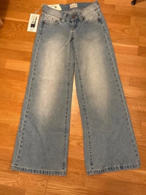 Ljusblå wide jeans  - Säljer ett par ljusblåa jeans från nelly som är helt nya! skit snygga som e lowwaist och lita baggy 💥det ser ut som de har nån grön fläck typ på baksidan av byxan men det är bara ljuset och det är ingen fläck! frågor kan diskuteras privat