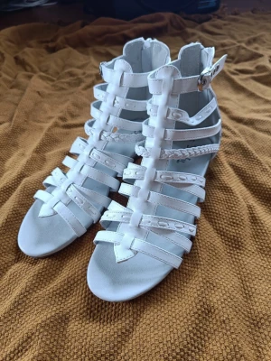 Sandalskor - Skor i sandalmodell, använda en gång främst innomhus. Mycket bra skick något till tryckta men inget som syns när man har dem på sig.