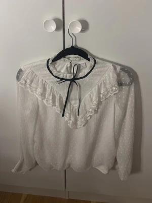 Vit blus - En vit blus med svart rosett från Lindex. 