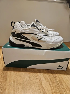 Puma RS-fast sneakers - Säljer ett par Puma RS-Fast sneakers i vit färg. Skorna har en sportig design med detaljer i svart. Perfekt för vardagsbruk.