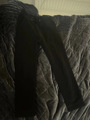 Svarta mjukisbyxor från 157 - Svarta mjukisbyxor från 157 med ribbad mudd i storlek 150. Byxorna är gjorda i mjukt material som känns skönt mot huden. Funderingar? Skriv till mig💕