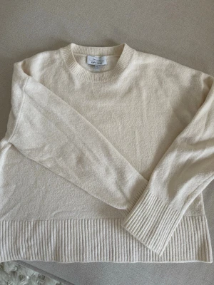  stickad tröja & Other Stories - & Other Stories vit stickad tröja – stl S  Stilren Creme vit stickad tröja från & Other Stories i storlek S. Tidlös modell som passar perfekt året runt, lika snygg till jeans som till kjol eller kostymbyxor.   Tillverkad i ett mjukt och bekvämt material med 54 % bomull, vilket gör tröjan skön att bära och lätt att använda både till vardag och jobb. Tröjan är i fint skick utan anmärkningar.  Detaljer: Märke: & Other Stories Storlek: S Färg: cremevit Material: 54 % bomull Skick: fint skick Stil: s