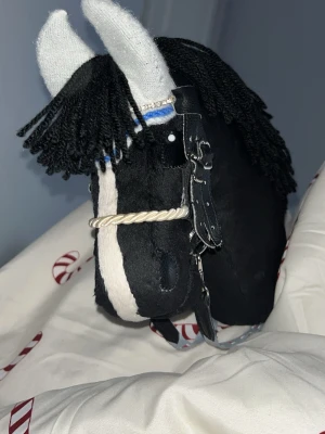 Svart käpphäst med vit lång bläs - Säljer en svart käpphäst med vit bläs och svart man. Det ingår lite utrustning 