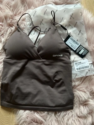 Dfyne Limited edition - Dfyne Vision twist front longline top i färgen truffle från ”the switch”, limited edition och slutsåld. Helt oanvänd (endast provad) med prislapp kvar. Storlek S❣️