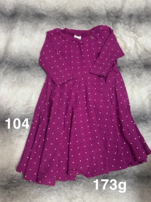 Lila prickig klänning med lång ärm - Söt lila klänning med prickar. Klänningen har trekvarts ärm och rund halsringning med knappdetalj på axeln. Perfekt för dig som gillar färg och mönster!🌸 Fint använt skick. Ej hellånga ärmar, Storlek 104 