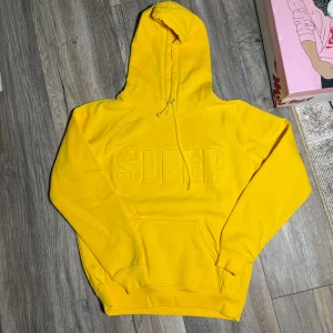 Gul hoodie från BikBok strl S  - Säljer en gul hoodie från BikBok i strl S, med texten ”sleep” på framsidan. 