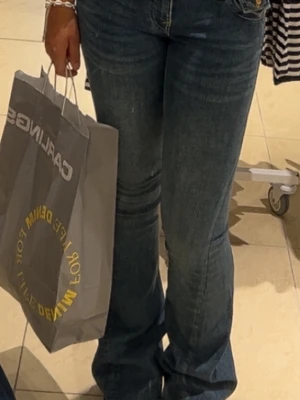 True Religion Joey Low Rise Flare Jeans - Säljer ett par blå True Religion Joey jeans med låg midja och flare-ben. Storlek 25. Säljer då dem är för stora i midjan.