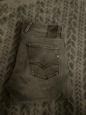 Replay Anbass  - Säljer ett par Replay anbass jeans i färgen mörkgrå. Jeansen är slimfit och är i storlek W34 Jeansen är i bra skick.  Etiketten utskuren: Ytterlängd 102cm. 