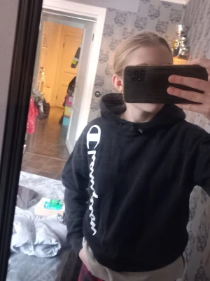 En svart Champion hoodie  - En svart Champion hoodie med knytning vid halskrage samt rund midjan. I st S(Normal I st). Passar jättebra med jeans eller mjukisbyxor.