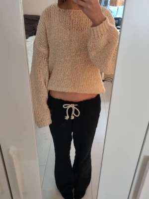 Stickad tröja - Säljer en ljusrosa/biege stickad tröja fråm cubusl. Tröjan har breda ärmar, ribbade muddar och en luftig stickning. Perfekt att slänga på sig över ett linne eller t-shirt under kyliga dagar.