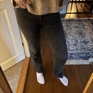 Svarta raka jeans - Säljer ett par svarta jeans med rak passform och klassisk femficksdesign. Jeansen har en något tvättad look och sitter normalt i midjan. Perfekta till en avslappnad stil och funkar året runt.