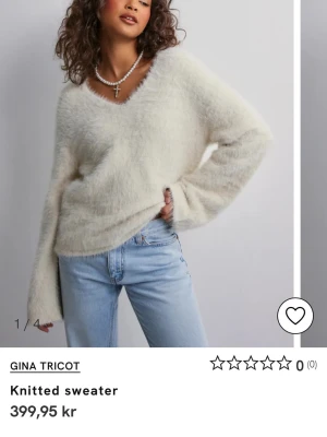 Vit fluffig stickad tröja Gina Tricot - Supermjuk och fluffig vit stickad tröja från Gina Tricot med v-ringning och långa ärmar. Tröjan har en lite lös passform och känns riktigt cozy, perfekt att mysa i under kyliga dagar. Säljer eftersom jag köpte fel storlek!💗