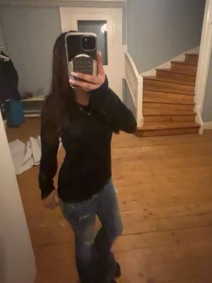 Svart stickad tröja med glitter - Säljer en svart stickad tröja med diskret glittriga detaljer. Tröjan har lång ärm och en liten v halsringning. Perfekt för dig som vill ha något enkelt men ändå med lite extra shine.