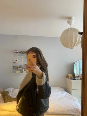 Svart teddyjacka från Zara - Säljer en svart teddyjacka från Zara med beige fuskpälsfoder och detaljer. Jackan har dragkedja, bred krage och bälte nertill. Perfekt oversized look och riktigt mysig med långa ärmar och mjukt material.