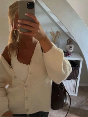 Vit stickad kofta med knappar - Storlek XL men är liten i storleken, se sista två bilderna för passform. Tycker snarare att den sitter som en m, slutsåld!