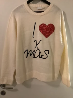Jultröja med paljetthjärta från Kappahl. Helt ny, medium,  - Vit stickad jultröja från Kappahl med texten 'I ❤️ xmas' framtill. Hjärtat är täckt av röda paljetter som ger extra julkänsla. Tröjan har rund hals och långa ärmar, perfekt för att maxa julstämningen. Medium. Helt ny. För stor för mig. Rymlig. Inga tags. Endast provad en gång. 