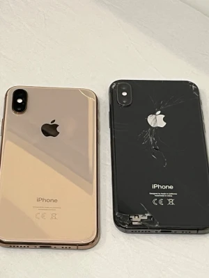 iPhone XS - Två iPhone XS säljes. En i guld med mindre repor, i gott skick. En i svart med sprucken baksida och skador i hörnet, säljs som reservdelar eller för reparation. Båda har dubbla kameror och elegant design. TAR ÄVEN BYTE!!
