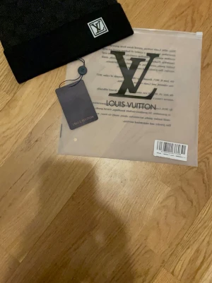 Svart LV sett - Säljer ett svart  sett från Louis Vuitton med klassisk LV-logga framtill. Västen har en stilren design och är tillverkad i ett mjukt material som känns lyxigt. Perfekt för dig som vill ha en exklusiv och trendig look.