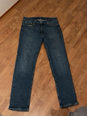 Blå Regular/Clark jeans 31/32 - Säljer ett par klassiska blå jeans i modellen Regular/Clark. De har rak passform, fem fickor och snygga kontrastsömmar. Perfekta för dig som gillar en enkel och tidlös look. Storlek 31/32. Nypris 999kr, mitt pris 599kr men de går såklart att diskutera!!