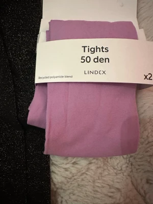 Lindex strumpbyxor  - 2 st strumpbyxor, en guldglittrande som är använd endast en gång och lila helt ny.