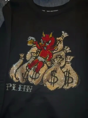 Philip plein tröja - Exlusiv philip plein tröja, Storlek M men sitter nice på S oxå.  Glänsig Philipp Plein-tröja i toppskick. Stilren, exklusiv design som sticker ut. Perfekt för fest eller vardag – äkta statement-plagg. (Knappt använd) SKRIV ANGÅENDE BYTEN, PRIS KAN DISKUTERAS.