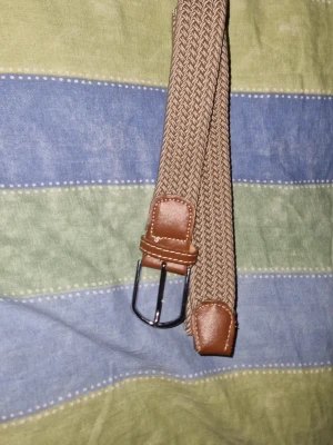 Flätat bälte i beige - Ett fint oanvändt bälte med storlek 90 men den e strech och passar upp till 120