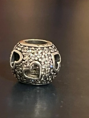 Pandora berlock äkta Silver 925 - Pandora  berlock i silver med hjärtdetaljer och gnistrande stenar. 