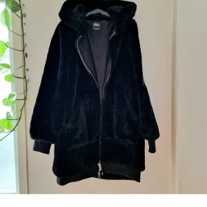 Svart fluffig jacka - Kappa med STOR huva i fuskpäls. Bästa med denna jacka är att man kan gömma hela ansiktet i MJUUUK fuskpäls på insidan av jackan. Inga sträva hårstrån här! Passar bra på höst och vinter 🐈‍⬛✨️🌙 som ny!